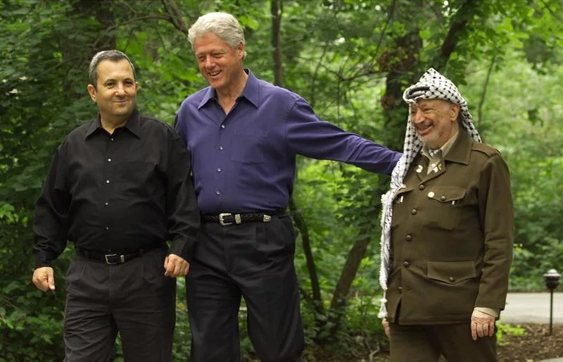 Then US President Clinton, center, with Israeli Prime Minister Ehud Barak, left, and Palestinian leader Yasser Arafat, right, walk on the grounds of Camp David, on July 11, 2000